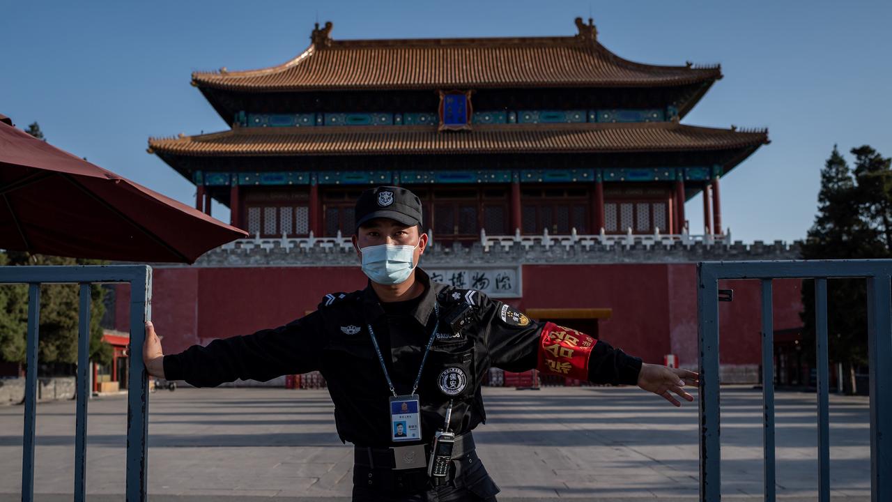 A security guard wearing a face mask amid concerns over the coronavirus closes a gate outside the Forbidden City in Beijing on Easter Sunday. Picture: Nicolas Asfouri/AFP