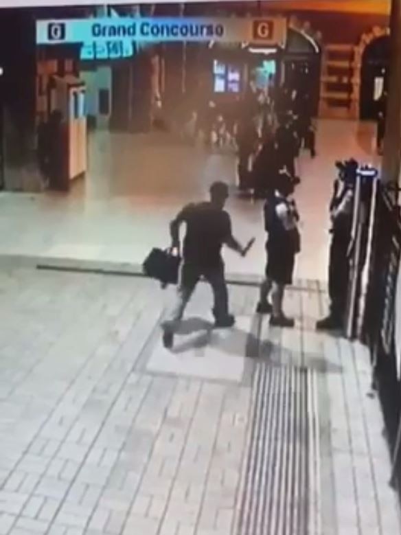 Screengrabs from a supplied video show Townsville man Mark Thompson stabbing a police officer in the back with a knife at Sydney's Central Station on Friday, April 19, 2019.