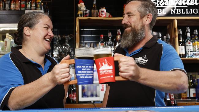 Steampacket Hotel Nelligen owners Melissa and Joel Alvey show off their stubby holders with the quote from Paul Parker to the PM during the Black Summer bushfires. Picture: Jonathan Ng