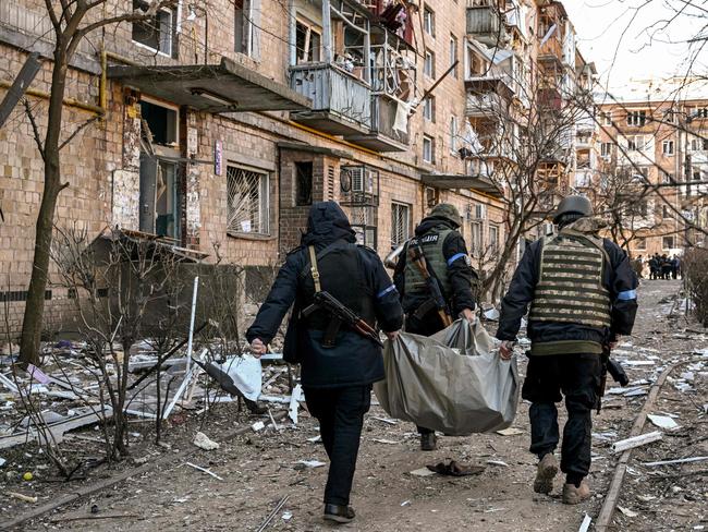 Ukrainian police carry a body away from a five-storey residential building that partially collapsed after a shelling in Kyiv as Russian troops try to encircle the city. Picture: AFP.