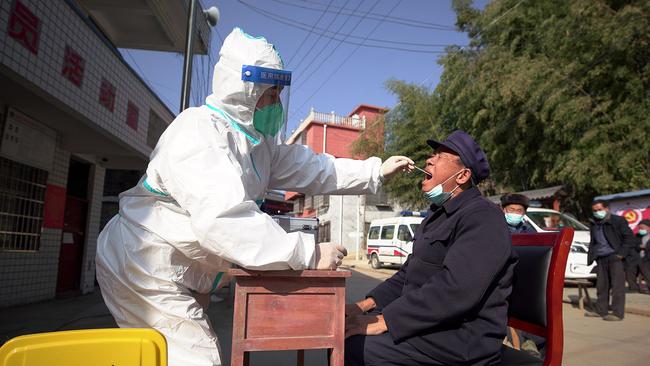 A health worker takes a swab sample from a man to be tested for the Covid-19 in Danzhai, in China's southwestern Guizhou province, as the virus runs rampant in the nation. Picture: AFP