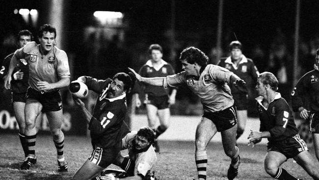 Queensland forward Sam Backo manages to get his pass away to Allan Langer. Picture by Jim Fenwick