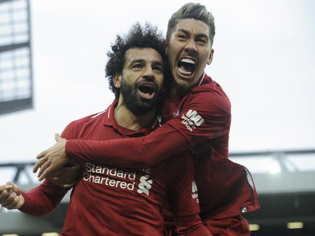 Liverpool's Mohamed Salah, left, and Liverpool's Roberto Firmino celebrate after Tottenham's Toby Alderweireld scores an own goal past his goalkeeper during the English Premier League soccer match between Liverpool and Tottenham Hotspur at Anfield stadium in Liverpool, England, Sunday, March 31, 2019. (AP Photo/Rui Vieira)