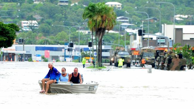 A tinnie travels along Charters Towers Road during the devastating floods. Picture: Evan Morgan