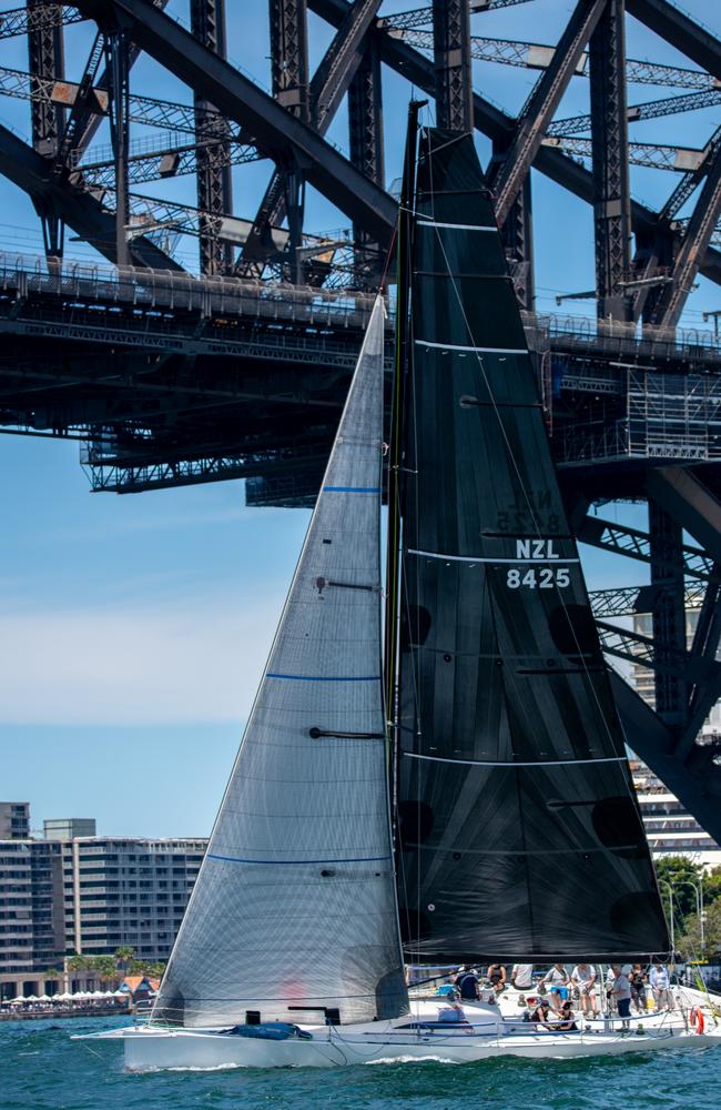 Perfect day for a race! A competitor sails under the Harbour Bridge. Picture: Thomas Lisson