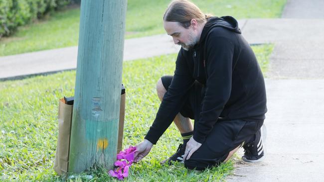 Neighbour Brendan Rhodes leaves flowers at the scene of the accident at Bushmead Street in Nerang. Picture: Annette Dew.