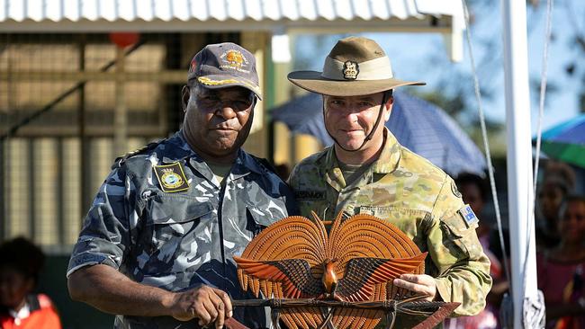 Commander of the 3rd Brigade, Brigadier David McCammon (right), DSM and Bar, accepts a gift from the Commanding Officer of Lombrum Naval Base, Commander Buni Dorea, during the closing ceremony of Exercise Puk Puk on Manus Island, Papua New Guinea. Picture: ADF