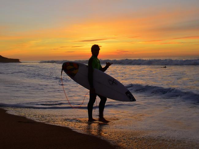 A surfer heads into the surf at sunrise ahead of the 2016 Rip Curl Pro at Bells Beach. Picture: Stephen Harman