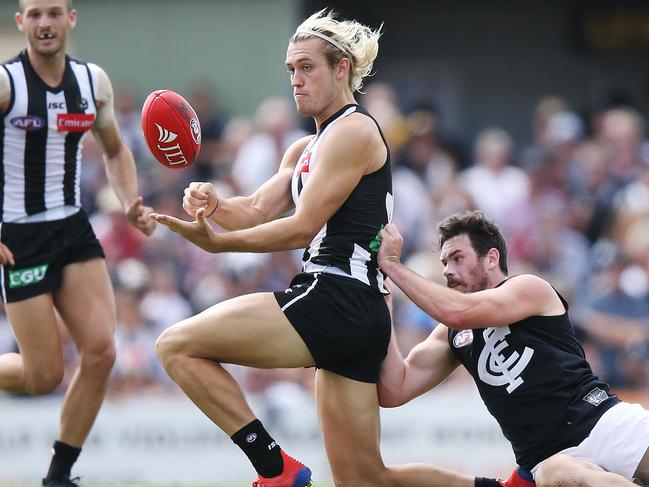 MELBOURNE, AUSTRALIA - MARCH 11: Darcy Moore of the Magpies handballs from Mitch McGovern of the Blues during the 2019 JLT Community Series match between the Collingwood Magpies and the Carlton Blues at Morewell Recreation Reserve on March 11, 2019 in Melbourne, Australia. (Photo by Michael Dodge/Getty Images)