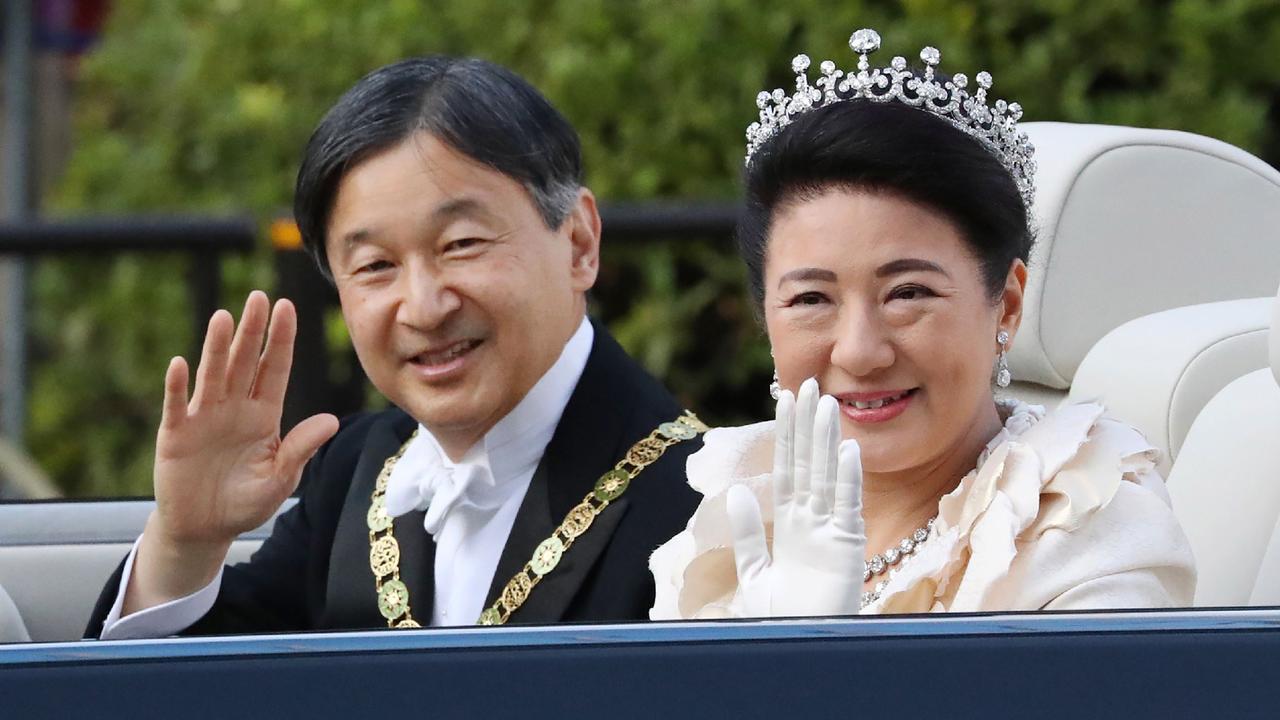 Japan’s Emperor Naruhito and Empress Masako wave during a royal parade in Tokyo. AFP.