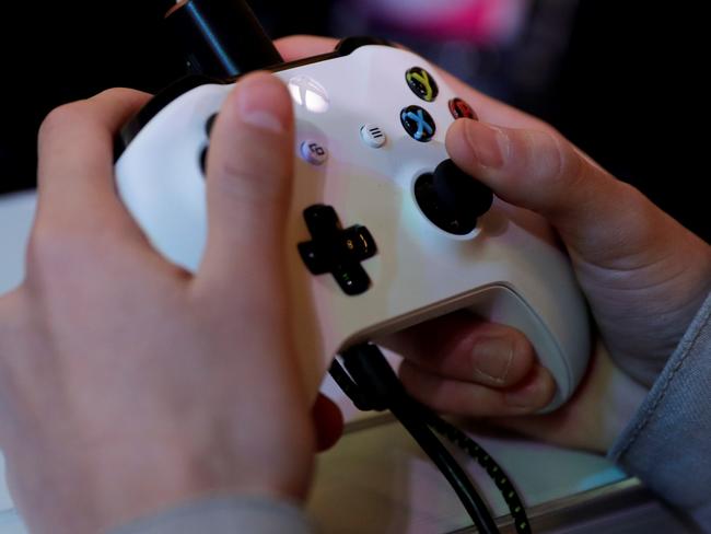 (FILES) In this file photo taken on November 5, 2017 a gamer plays video games with a Xbox console during the 2017 Paris Games Week exhibition at the Porte de Versailles exhibition centre in Paris. Video gaming can be addictive in the same way as cocaine or gambling, the World Health Organization said on June 18, 2018 in a much anticipated update of the International Classification of Diseases (ICD-11). / AFP PHOTO / Thomas SAMSON