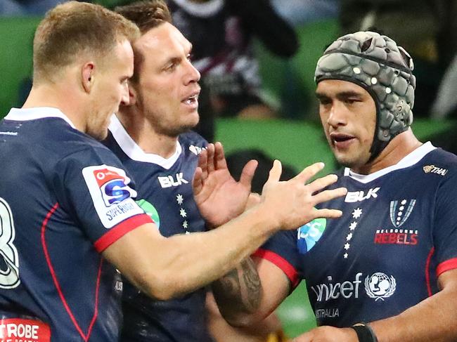 MELBOURNE, AUSTRALIA - MAY 10: Dane Haylett-Petty of the Rebels  is congratulated by Reece Hodge of the Rebels, Tetera Faulkner of the Rebels and Quade Cooper of the Rebels after scoring a try  during the round 13 Super Rugby match between the Rebels and the Reds at AMI Park on May 10, 2019 in Melbourne, Australia. (Photo by Scott Barbour/Getty Images)