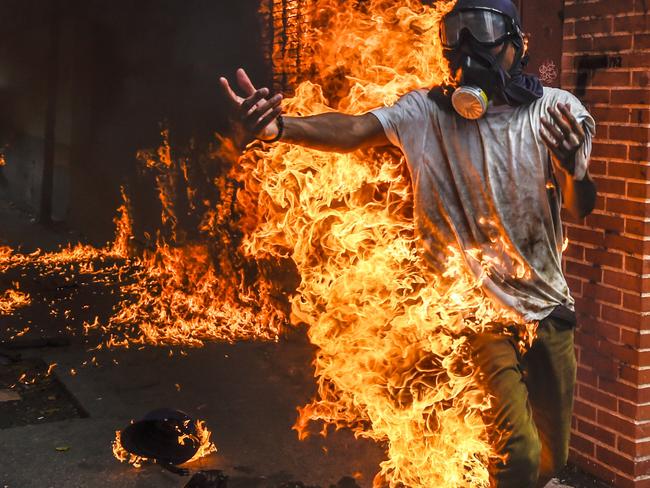 A demonstrator catches fire, after the gas tank of a police motorbike exploded, during clashes in a protest against Venezuelan President Nicolas Maduro, in Caracas last month. Picture: Juan Barreto/AFP