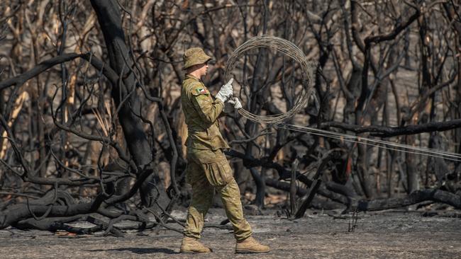 BlazeAid volunteer Ross Murray working with Army Reservists to replace stock fencing on Josh Graham's property. Picture: Brad Fleet