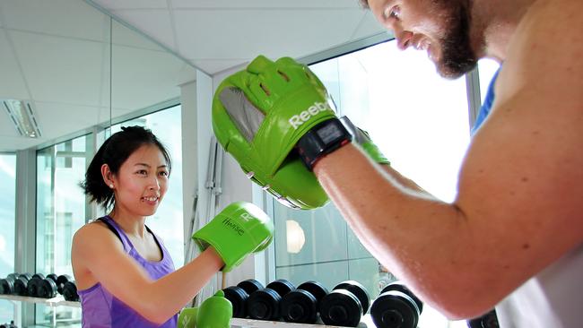 CMNEWS_Flight Centre staff members Chloe Pham and Jason Ruttley completing a gym session inside the company office personal gymnasium this afternoon Wednesday June 18, 2014. Pictures: Jack Tran / The Courier Mail