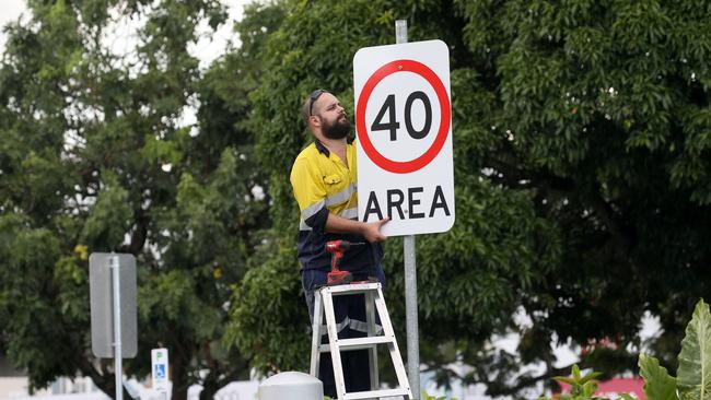 A council worker installs a 40km/h sign. Picture: Anna Rogers