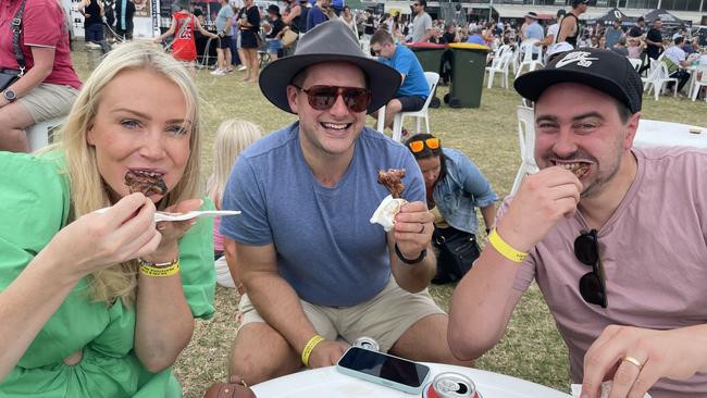 Kim Stribley, James Syme and Matt Stribley tuck into some Lamb Chops with Rum and Cue sauce at Meatstock 2023 at the Melbourne Showgrounds.