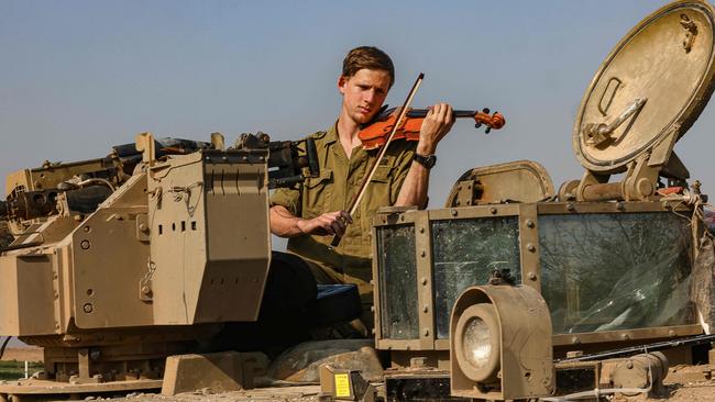 An Israeli soldier plays violin in a break from the fighting. Picture: AFP