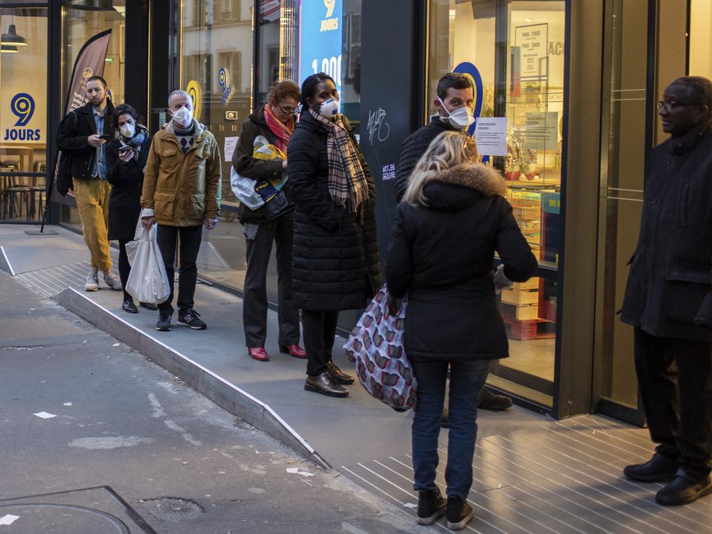 People with a protective masks line up using social distancing to queue at a supermarket in Paris. Picture: AP Photo/Rafael Yaghobzadeh