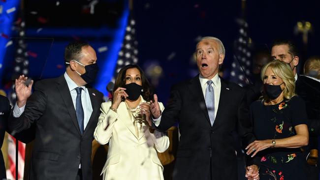 US President-elect Joe Biden and Vice President-elect Kamala Harris react as confetti falls, with Jill Biden and Douglas Emhoff, after being declared the winners of the presidential election.