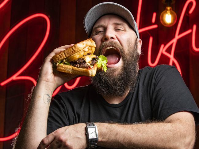 Mathew Rolo from West End eatery Hash-tag Hamburgers & Waffles, shows off the 'Get Litt' hailed as Queensland's best burger as judged by Australia's top competitive eater Cal Stubbs. Picture Lachie Millard