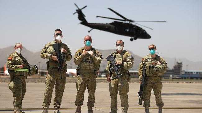 Australian troops prepare to board a RAAF C17 aircraft at the Hamid Karzai International Airport in Kabul, Afghanistan in June, as a Black Hawk helicopter takes off behind them. Picture: NCA NewsWire / Gary Ramage