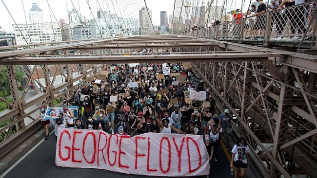 Protesters walk over the Brooklyn Bridge following a memorial service for George Floyd, the man killed by a Minneapolis police officer.