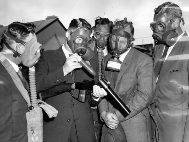 1959: In South Australia, gas-masked members of CIB demonstrate a new tear gas riot gun. Left to right: Detective D. O'Doherty, Detective-Sergeant L. Harper, Detective-Sergeant L. Brown and Detectives J. Zeunert and B. Stewart.