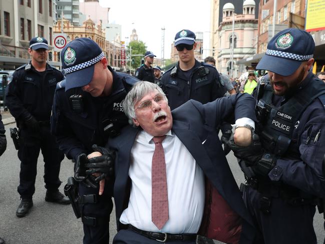 The scientists was hauled away to a waiting police van and was tended to by paramedics. Picture: Richard Dobson