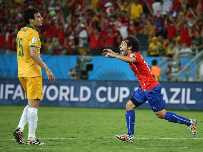 Australia's Mile Jedinak looks on as Jorge Valdivia of Chile scores the second goal.