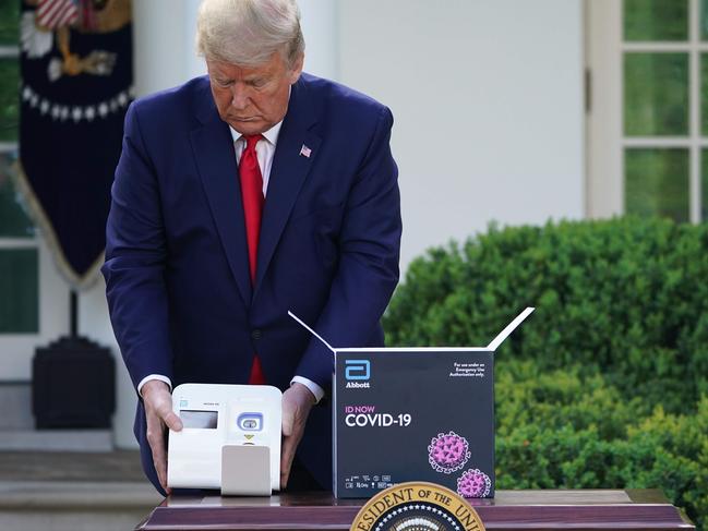 US President Donald Trump holds a 5-minute test for COVID-19 from Abbott Laboratories during the daily briefing on coronavirus in the Rose Garden of the White House in Washington, DC, on Thursday. Picture: MANDEL NGAN/AFP)