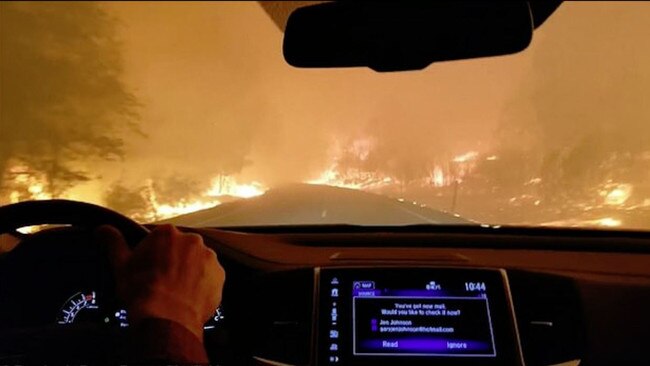 A family drives to safety as bushfires rage around a Californian road. Picture: Supplied