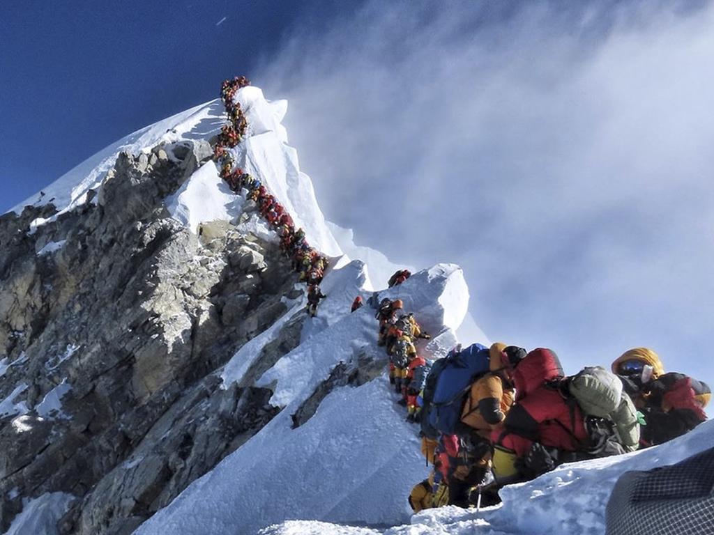 A long queue of mountain climbers line a path on Mount Everest.