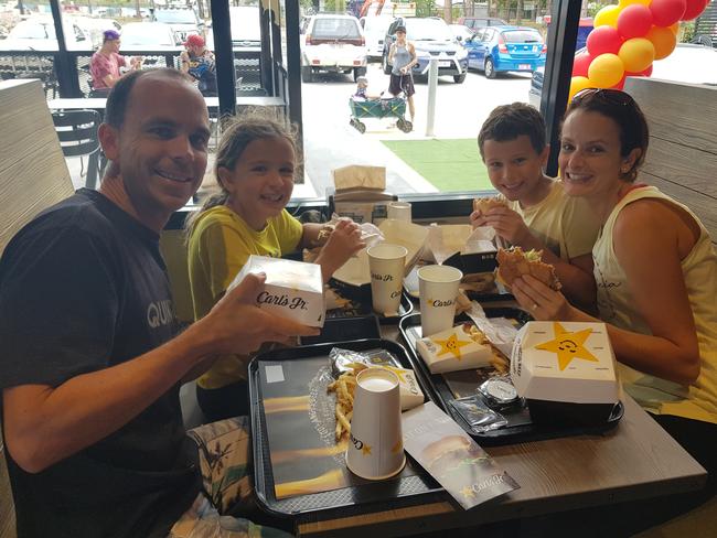 Nathan, Lydia, Hayden and Michelle Young enjoying their free Carl's Jr burgers at Rothwell. Picture: Erin Smith