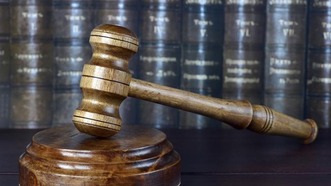 Wood gavel and soundblock on the background of shelves of old books