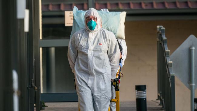 Healthcare workers move a resident of the aged care home. Picture: Jason Edwards