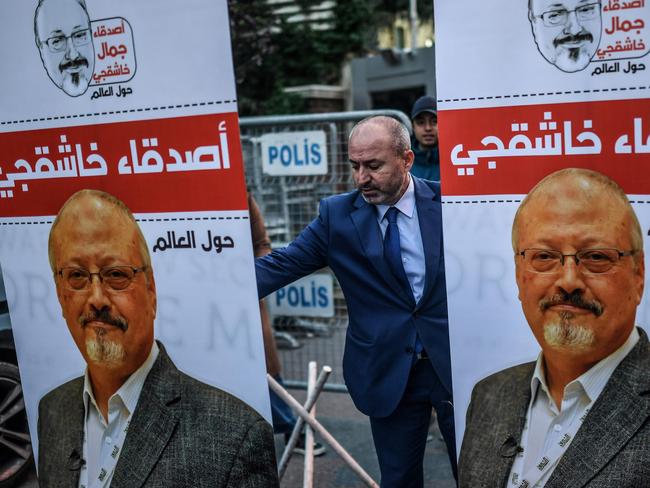 A man settles posters picturing Saudi journalist Jamal Khashoggi outside the Saudi Arabia consulate in Istanbul, on October 25, 2018 during a demonstration. - Jamal Khashoggi, a Washington Post contributor, was killed on October 2, 2018 after a visit to the Saudi consulate in Istanbul to obtain paperwork before marrying his Turkish fiancee. (Photo by BULENT KILIC / AFP)