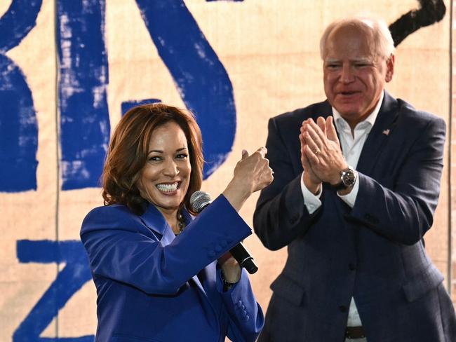 TOPSHOT - US Vice President and Democratic presidential candidate Kamala Harris (L) speaks as her running mate Minnesota Governor Tim Walz looks on during a stop on their campaign bus tour in Rochester, Pennsylvania, on August 18, 2024. (Photo by ANGELA WEISS / AFP)