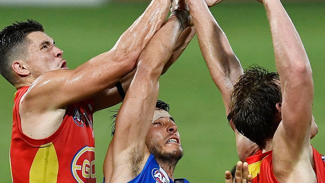 Ben Ainsworth and Tom J. Lynch of the Suns contest the ball with Shaun Atley of the Kangaroos during the round one AFL match between the Gold Coast Suns and the North Melbourne Kangaroos at Cazaly's Stadium on March 24, 2018 in Cairns, Australia. (Photo by Ian Hitchcock/Getty Images)