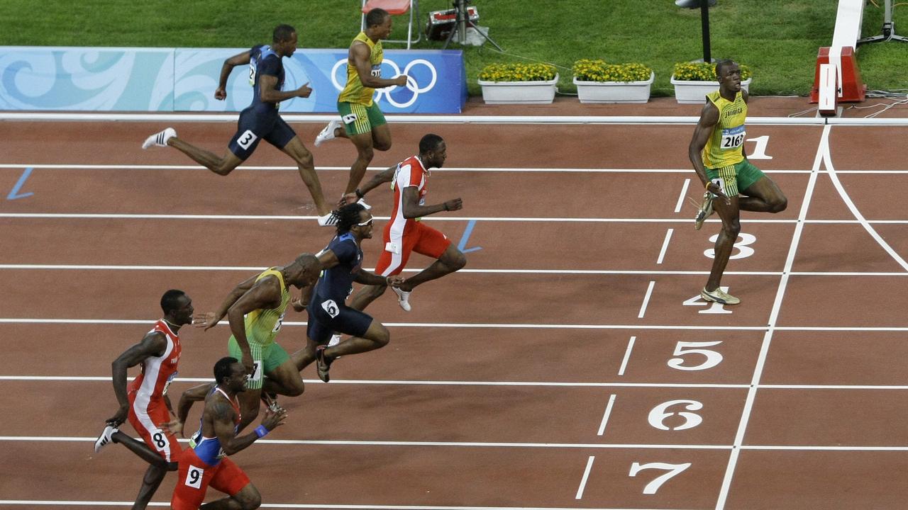 Jamaica's Usain Bolt, right, crosses the finish line to win gold in the men's 100m final at the 2008 Beijing Olympics.