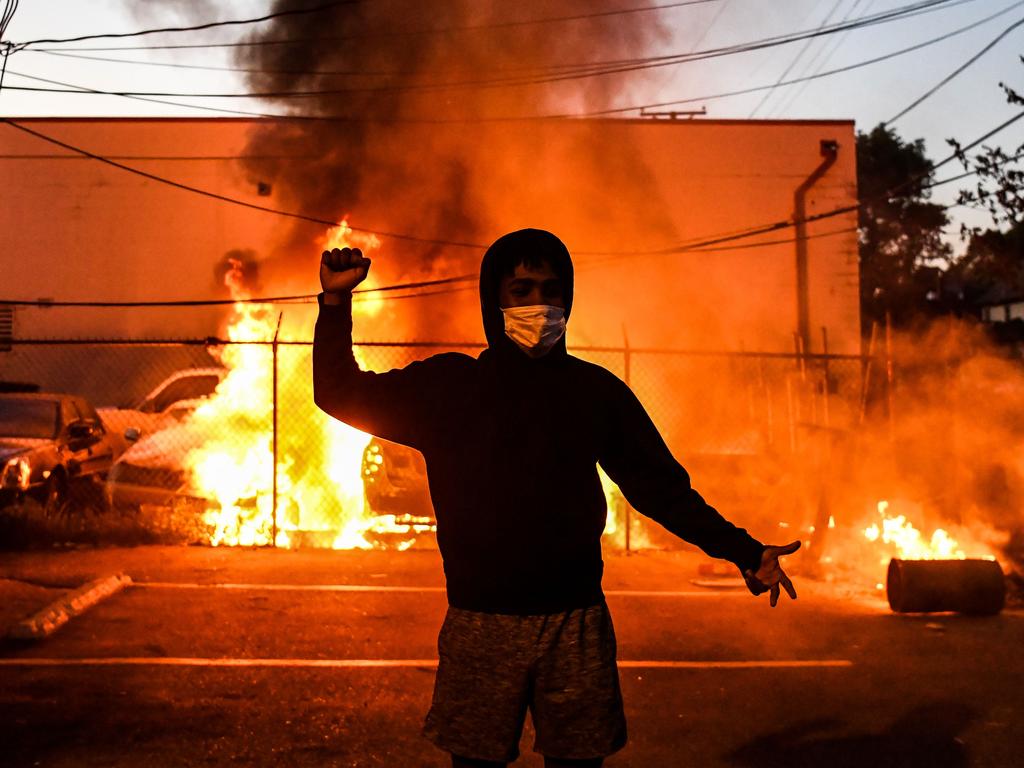 A protester gestures as cars burn behind him during a demonstration in Minneapolis, Minnesota, on May 29 over the death of George Floyd. Picture: Chandan Khanna