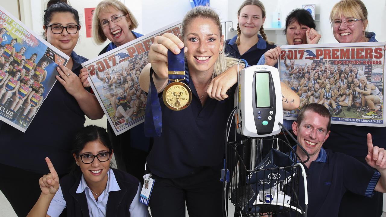AFLW - AFLW Crows premiership player Deni Varnhagen back to work as a nurse at the QEH with her colleagues after the historic win.(clockwise from Deni) Justine Samra, Marie Buonsanto, Helen Neindorf (ward clark) Natasha Rowe, CSC Jane Gould, Sheree McNamara and David Dewick. Picture Sarah Reed