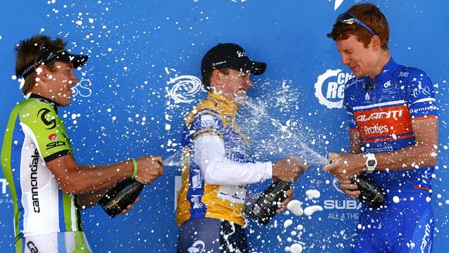 Tour winner Simon Clarke of the Orica GreenEdge team gets a champagne shower from Cameron Wurf (left) and Jack Haig (right) on the podium after Sunday’s final stage was canmcelled. Picture: Michael Klein