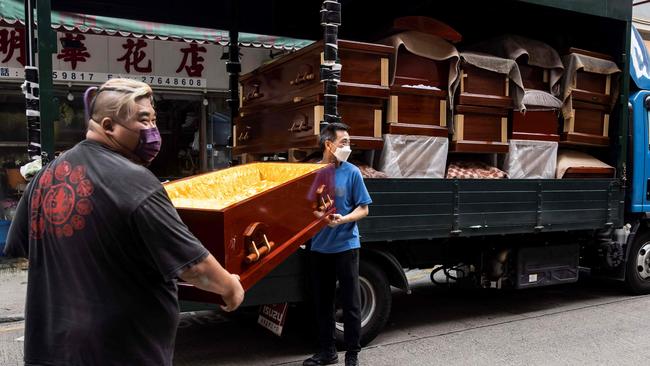 Empty coffins are delivered to a funeral services shop and funeral parlours in the Kowloon district of Hong Kong as deaths from Covid soar. (Photo by ISAAC LAWRENCE / AFP)