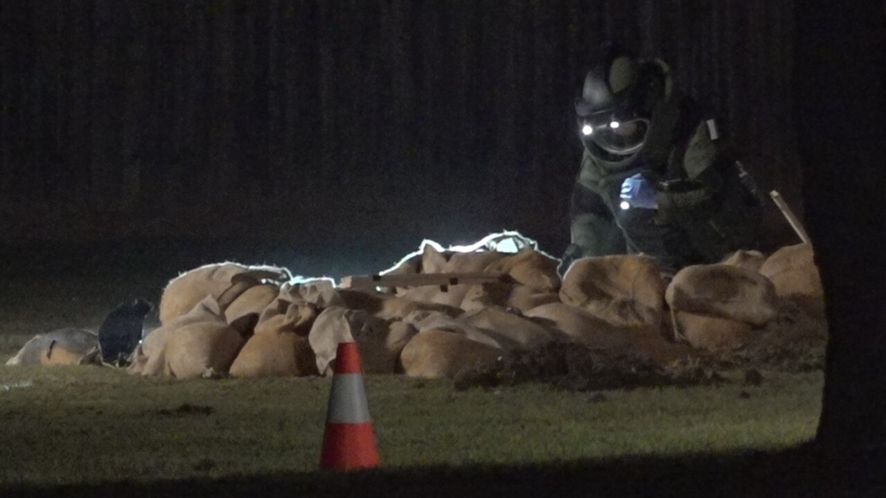 A bomb technician searches through sand bags. Picture: Lincoln Holmes