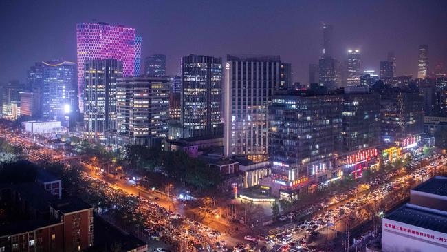 TOPSHOT - This picture taken on April 16, 2018 shows the city centre of Beijing at night amid pollution. / AFP PHOTO / Fred DUFOUR