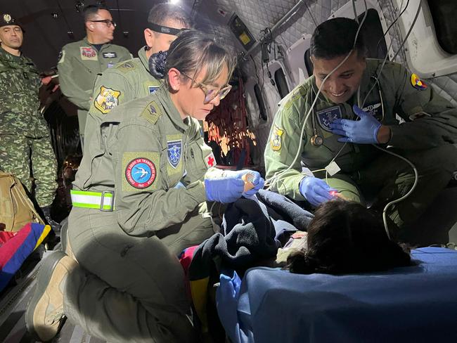 A Colombian Army personnel member smiles as he treats one of the children. Picture: Handout Colombian Air Force / Colombian Air Force / AFP