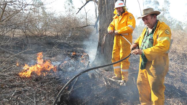 DOING WHAT THEY CAN: Brett Nagel and Bruce Wagner fight the blaze at Spicers Gap Rd. Picture: Annette Dew.