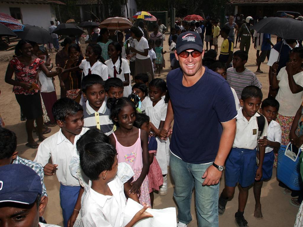 Shane Warne with local children during his visit to the tsunami-hit Galle cricket ground. Photo: News Corp