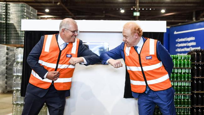 Prime Minister Scott Morrison and Visy executive chairman Anthony Pratt elbow bump during a visit to Visy Manufacturing in Penrith. Picture: Flavio Brancaleone